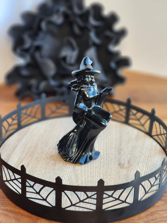 Hand Carved Crystal Obsidian Witch. This intricate carvings is a 3D Witch sitting on a Broom and ready to fly out for Halloween. Perfect for your Spooky Season decor.