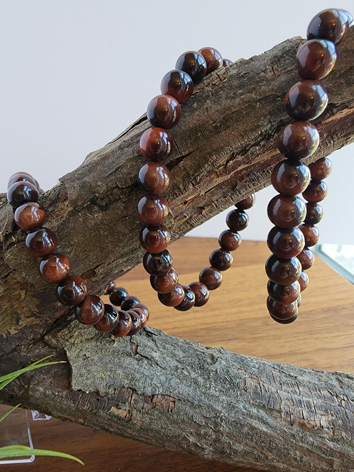 A collection of brown wooden beads arranged on a wooden surface, creating a rustic and natural aesthetic.