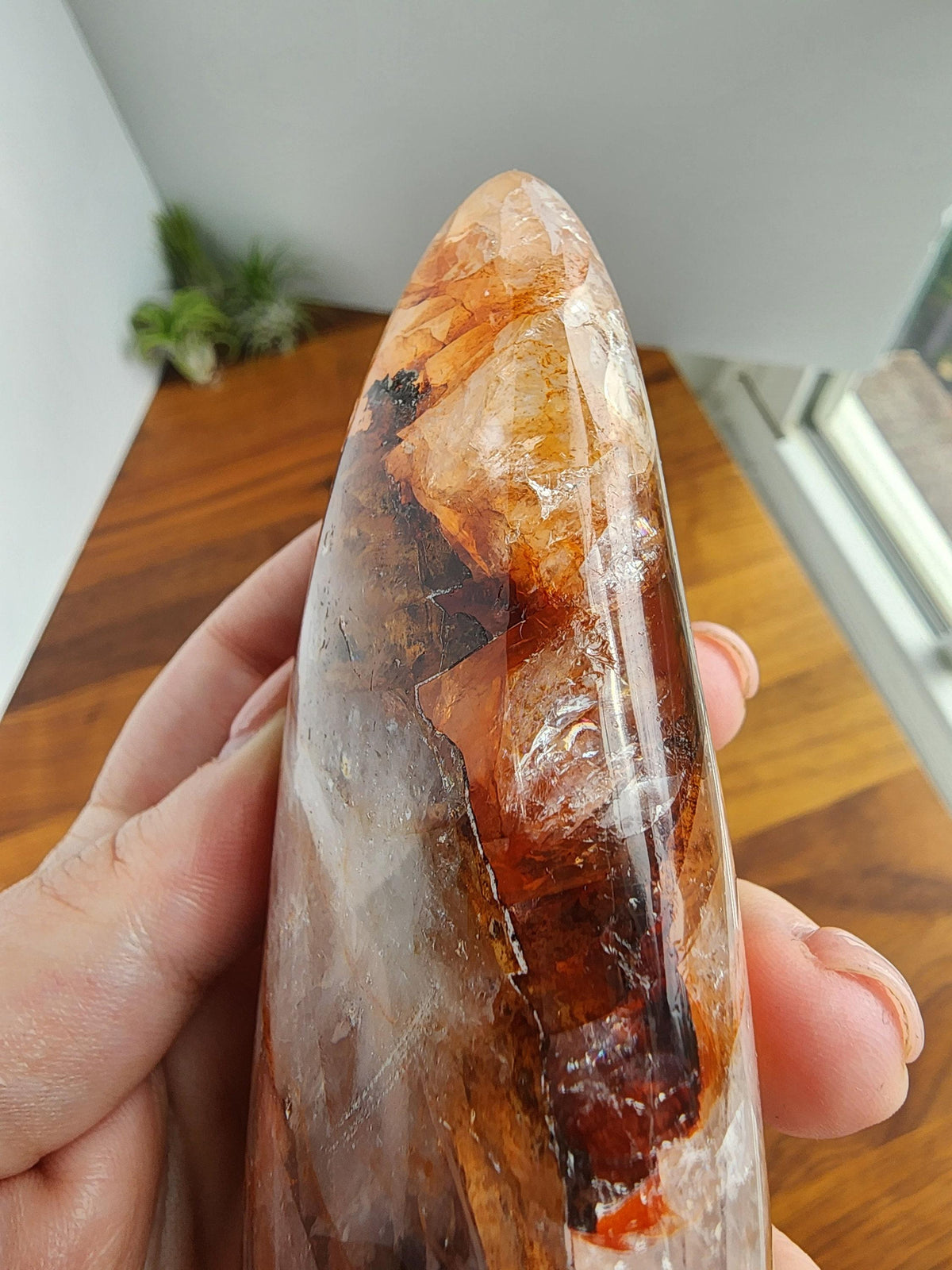 A hand is holding a piece of jade with a unique, multicolored pattern.