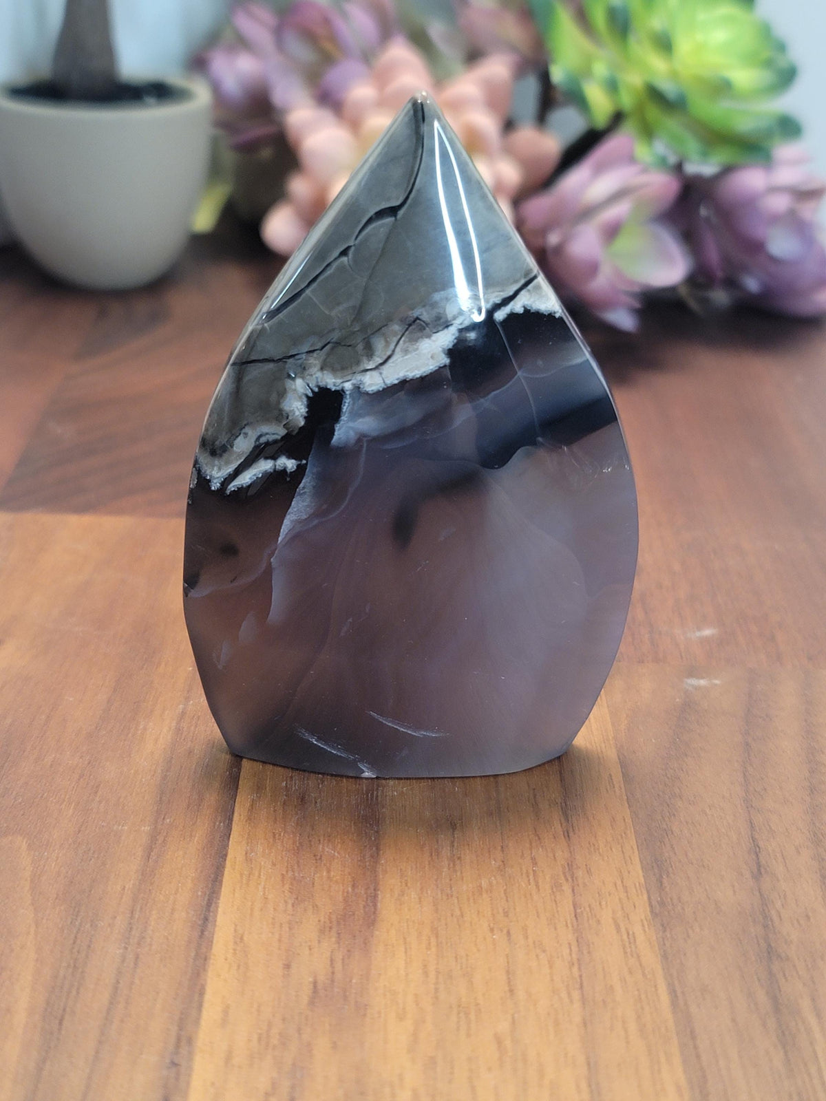 May include: A black and white agate freeform point with a polished finish. The point is shaped like a teardrop and has a smooth, glossy surface.