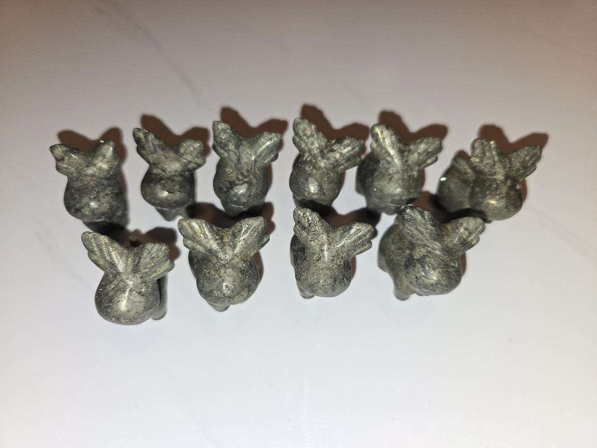 A group of nine small, silver-colored metal figurines arranged in a row on a white surface.