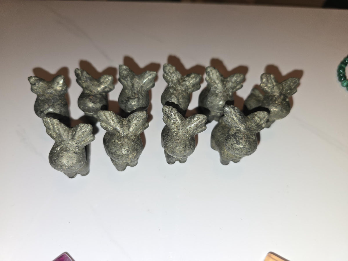 A group of small, gray metal figurines arranged on a white surface.