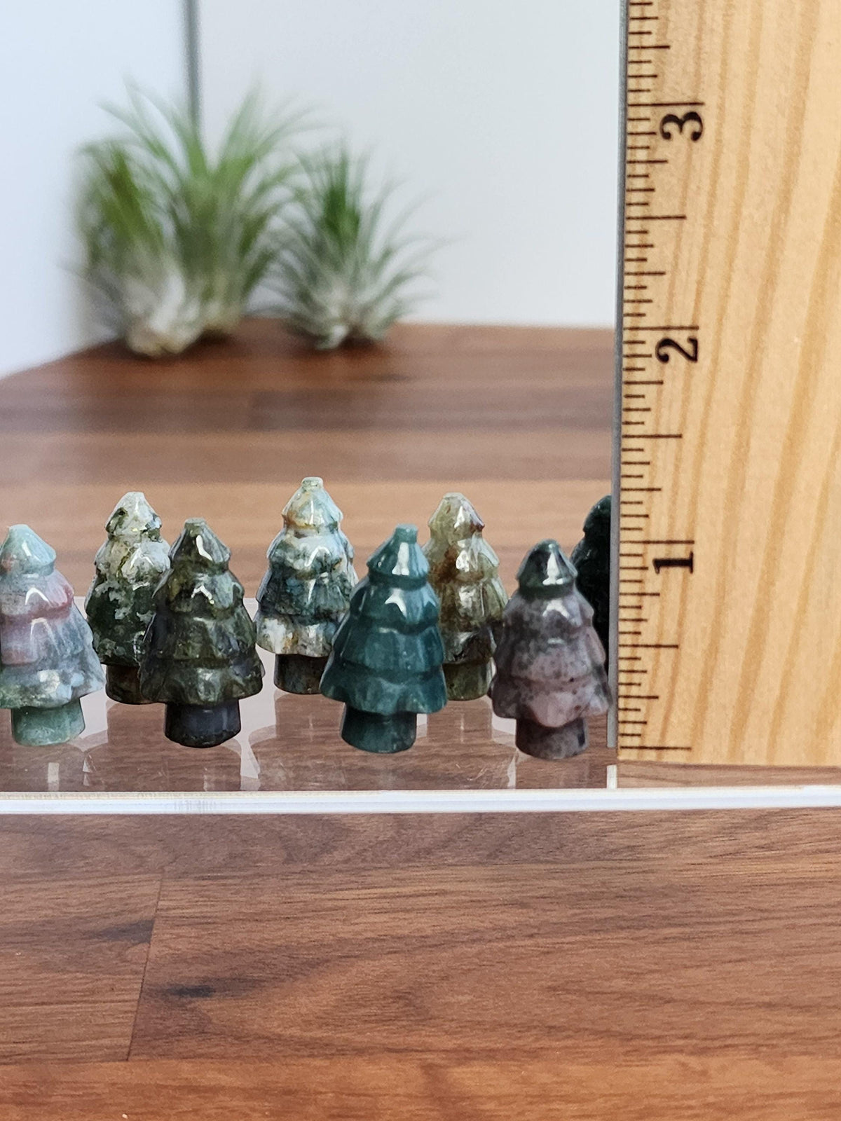 a collection of small, colorful tree-shaped objects, likely made of a material that resembles wood or stone, placed on a wooden surface.